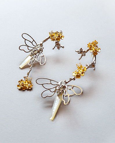 A pair of Lei butterfly twig earrings in silver with open wire wings, mother-of-pearl batons and small gold-plated blossoms.