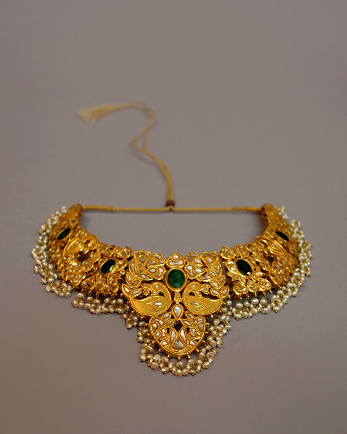 The Mumtaz peacock necklace: a gold-plated kundan collar with facing peacocks, emerald cabochons and a deep fringe of seed pearls.